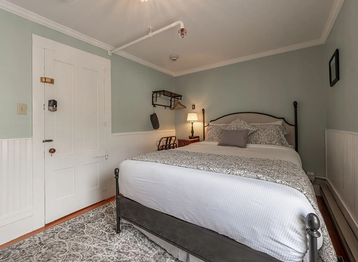 Hotel room with pale mint green walls in a petite queen room in North Conway