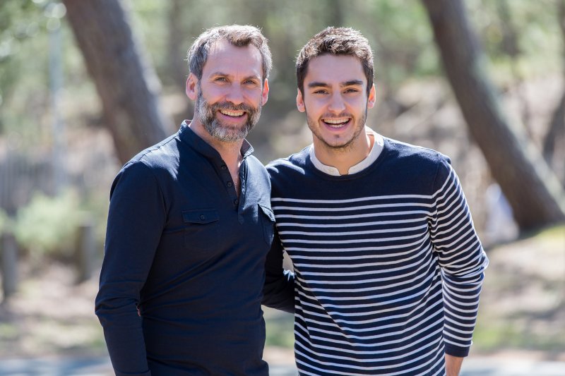 adult son with dad in the woods