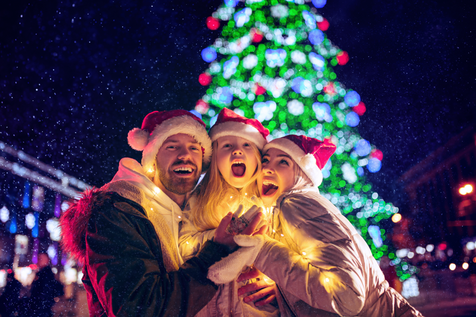 young family in front of Christmas tree in North Conway